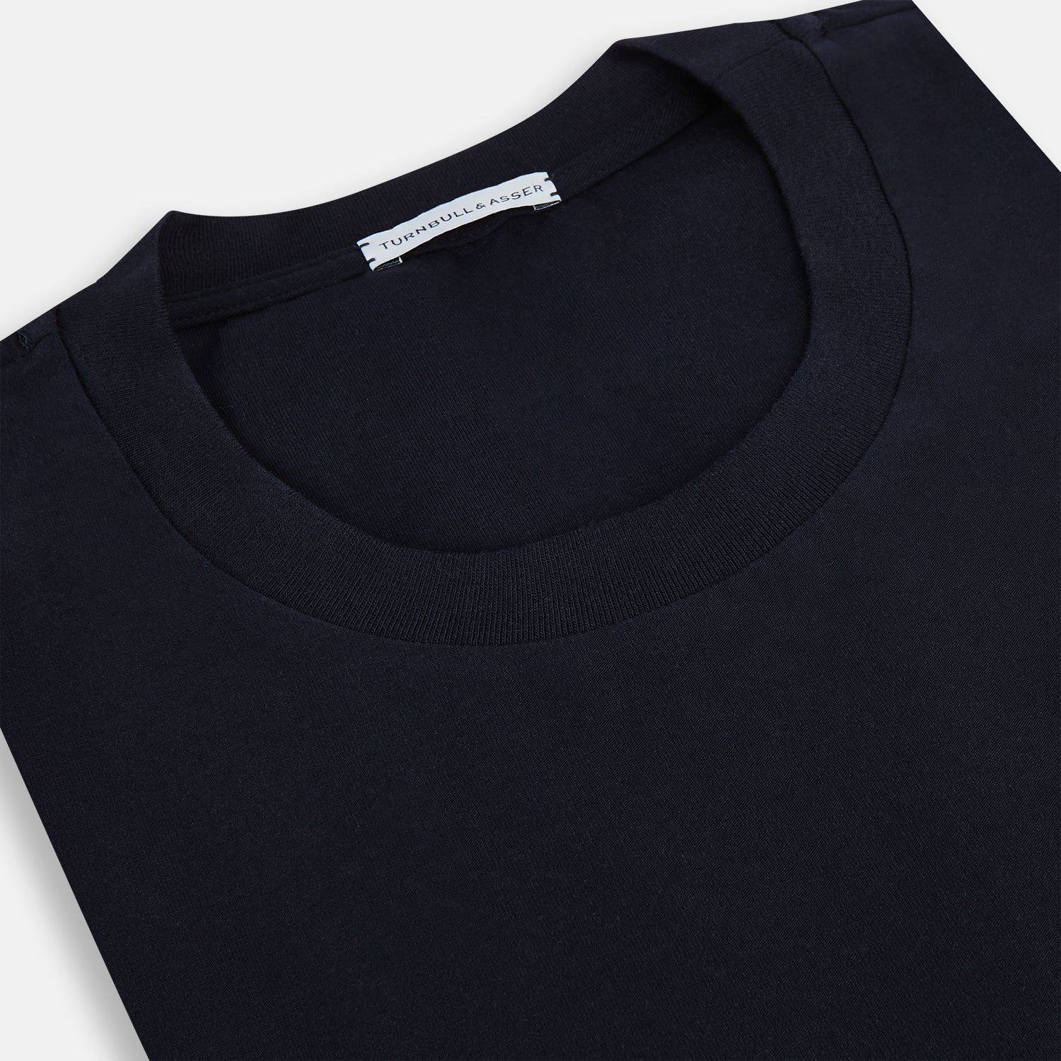 View 2 of product A navy short-sleeve pyjama shirt by Turnbull & Asser is laid flat on a white background, featuring a round neckline and a minimalist design—perfect for relaxed wear.