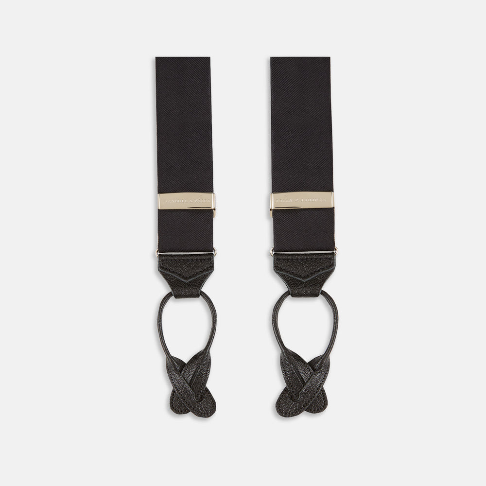 The Turnbull & Asser Black Herringbone Adjustable Silk Braces feature leather button loops and silver metal clips, shown on a white background—an elegant accessory to elevate any outfit.