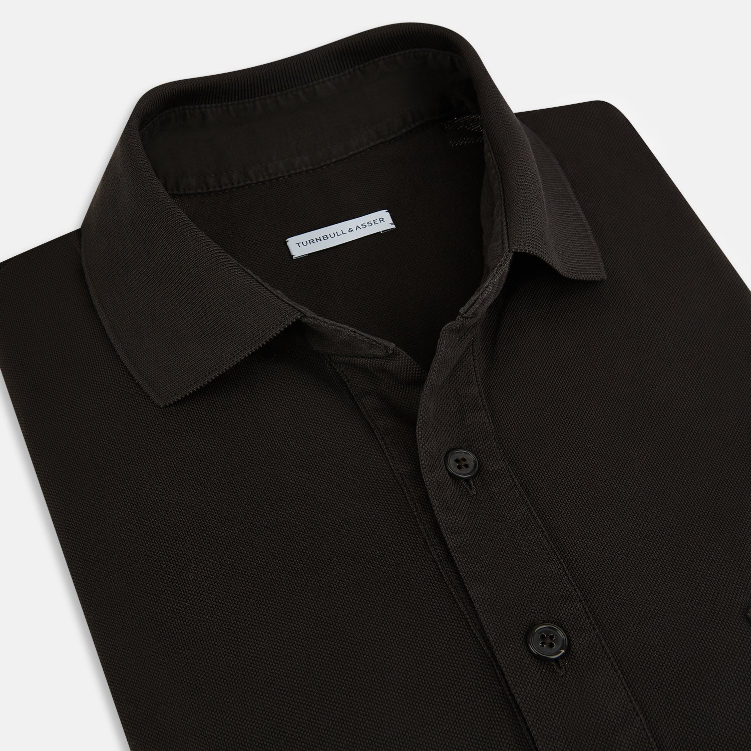 View 2 of product A brown short-sleeve polo shirt by Turnbull & Asser, crafted from pure cotton jersey with a collar, three buttons, and a buttoned chest pocket, laid flat on a white background.