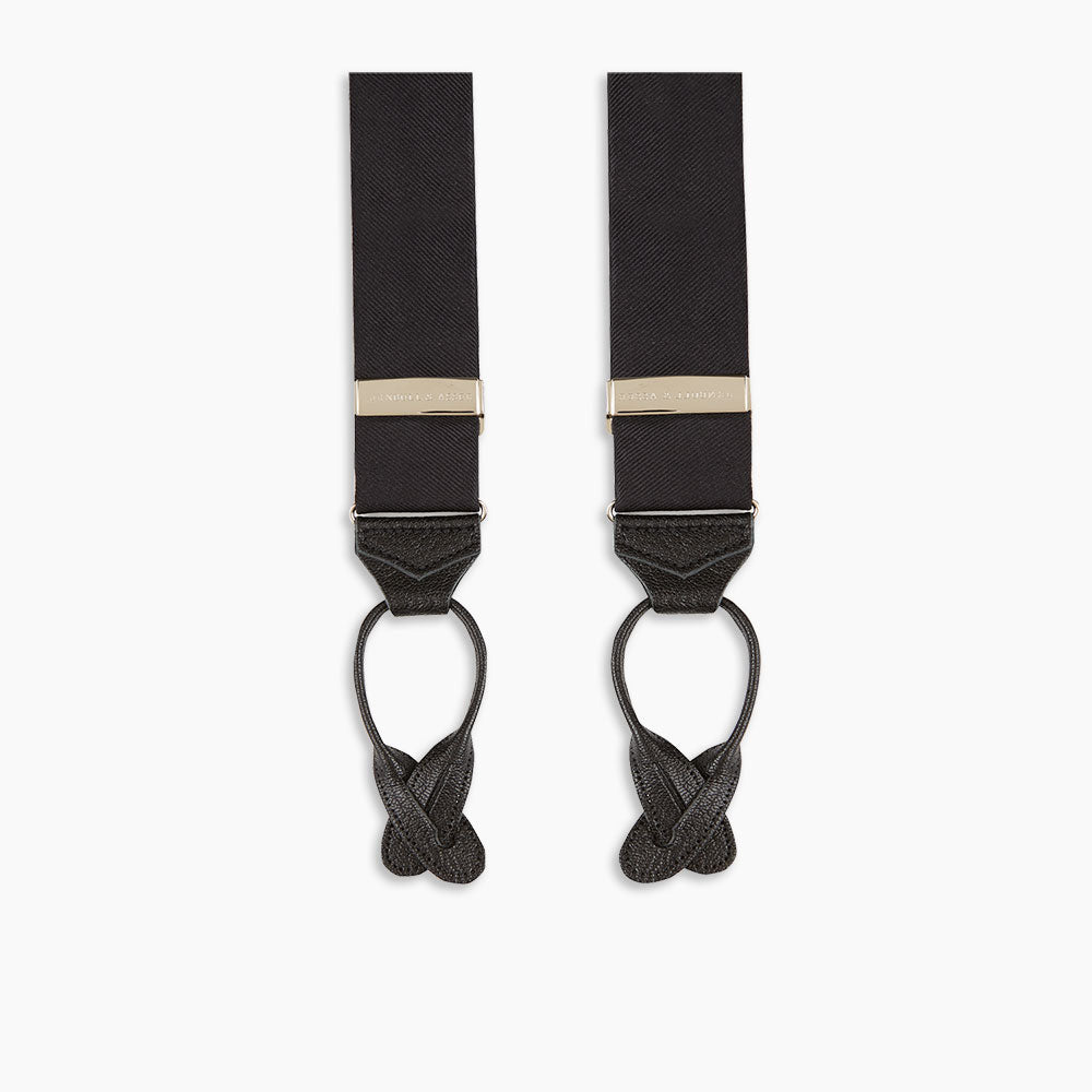 The Turnbull & Asser Black Herringbone Adjustable Silk Braces feature leather button loops and silver metal clips, shown on a white background—an elegant accessory to elevate any outfit.